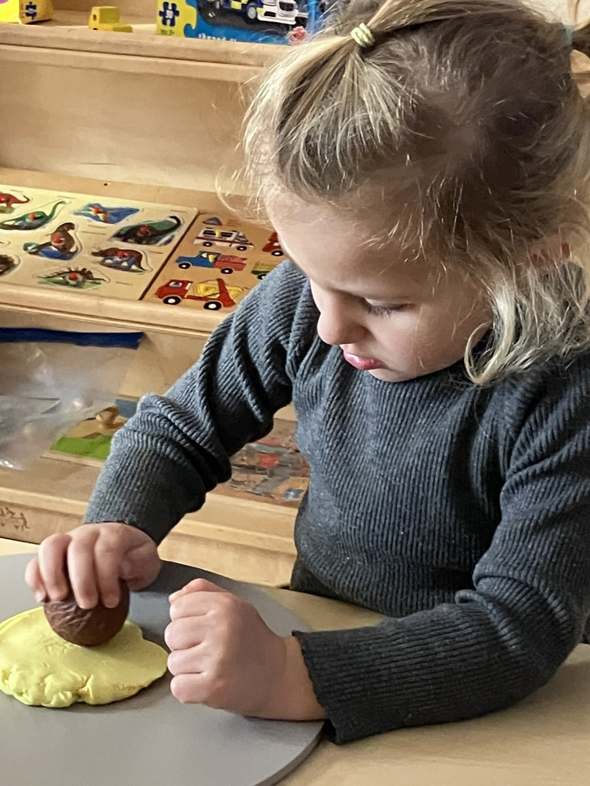 Kisgyermek a Yellow Door Vadállatok mintázó gömbökkel készít állati mintákat gyurmába.