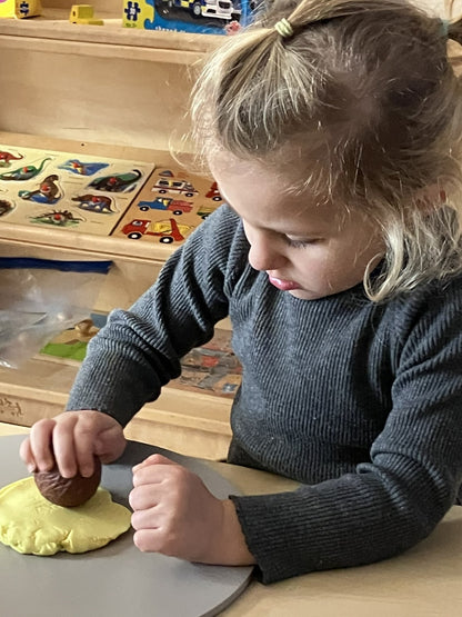 Kisgyermek a Yellow Door Vadállatok mintázó gömbökkel készít állati mintákat gyurmába.